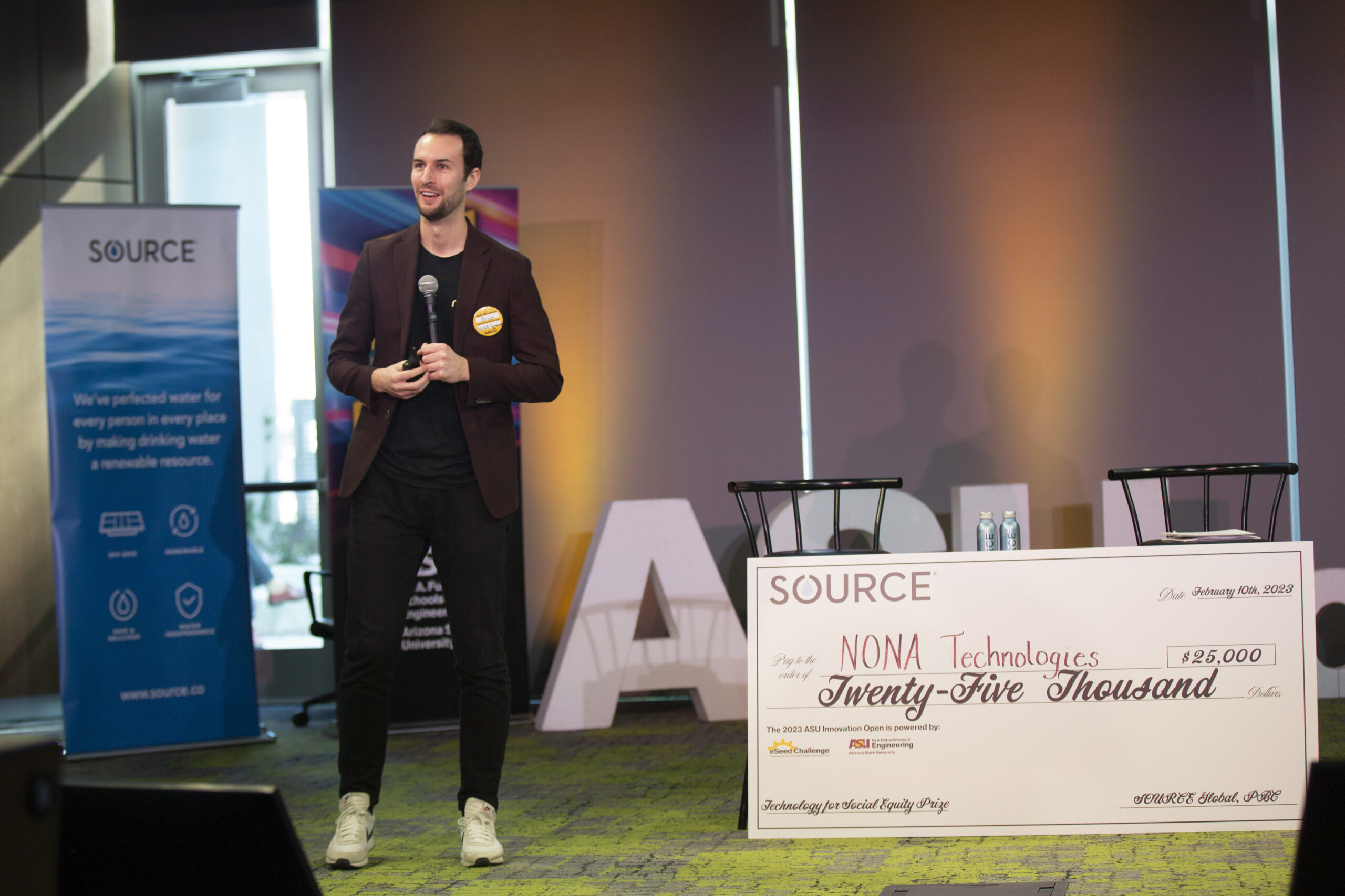 MIT graduate student Bruce Crawford accepts the $25,000 Social Equity prize from SOURCE Global on behalf of his startup, NONA Technologies, for its work in water desalination.
