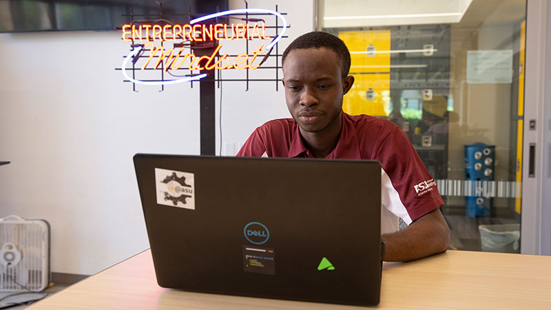 ASU student in front of his laptop, hard at work envisioning.